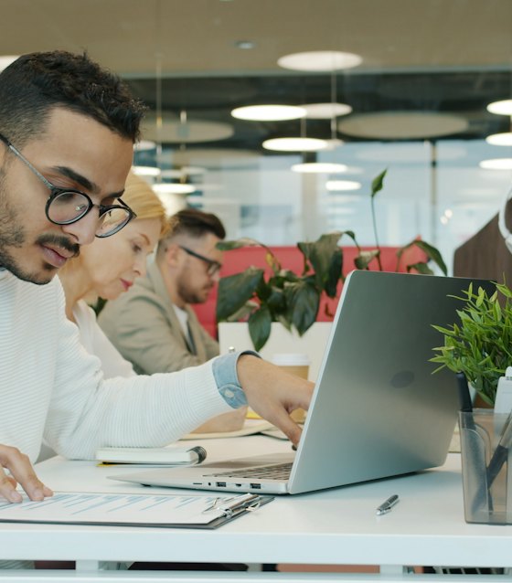An accountant reviewing a client file at a laptop