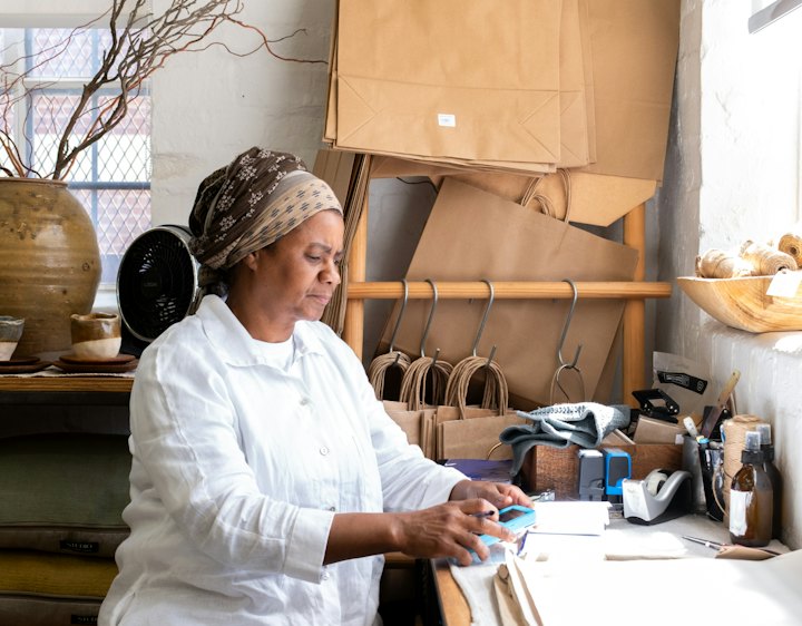 A self-employed maker working at her studio desk
